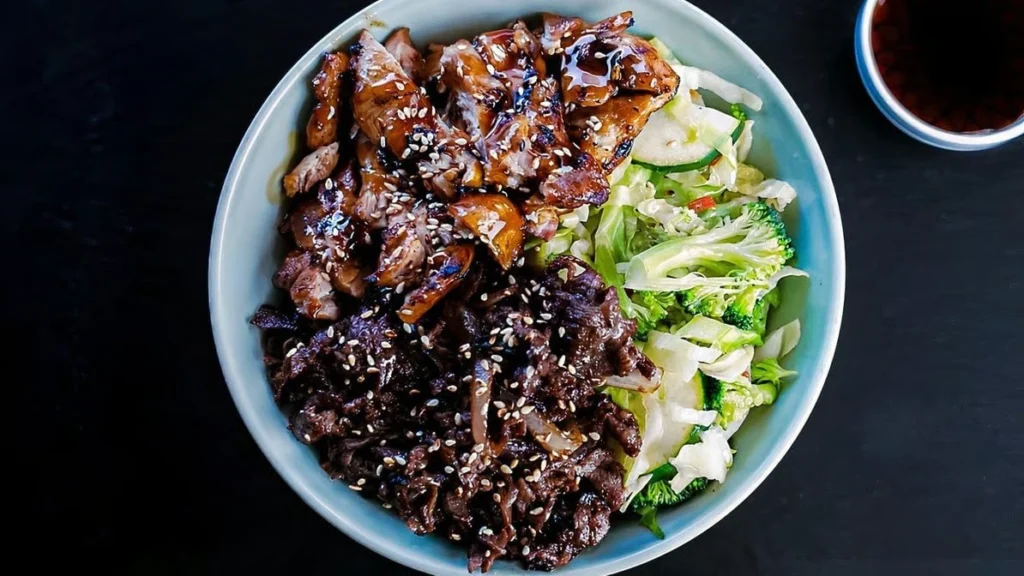 greens bowl with marinated chicken, mushrooms, broccoli, and cabbage