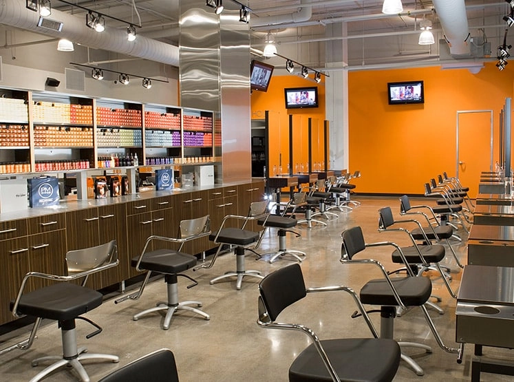 Paul Mitchell hair salon with many hair cutting stations and a wall of hair dye